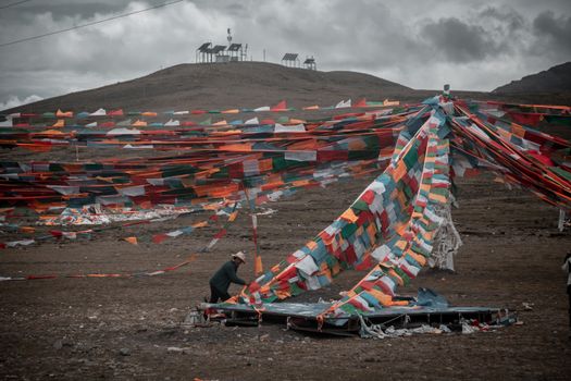 Vibrant Tibetan prayer flags on a hill in Tibet, symbolizing spirituality and cultural significance.