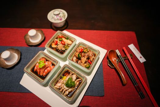 Top view of an elegant Asian seafood meal setting with various dishes and utensils.