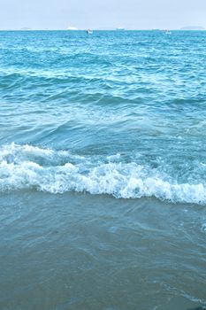 Tranquil view of blue waves gently crashing on the shore in Xiamen, Fujian, China.