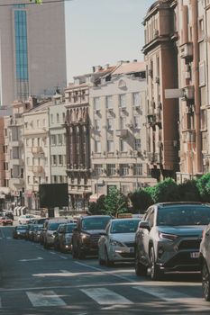 Busy traffic scene in Belgrade, Serbia with city buildings and vehicles on a sunlit street.