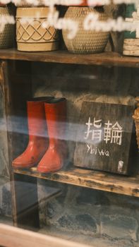 Rustic wooden shelf with red boots and a hand-painted sign.