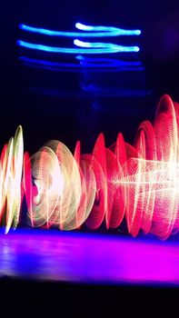 Vivid light trails create dynamic patterns at a nighttime performance in Kamloops.
