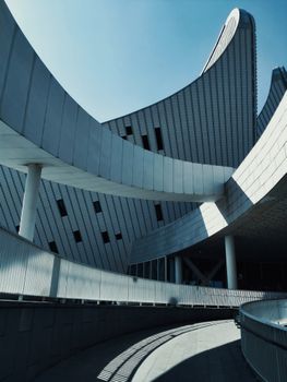 Striking modern architectural design with sweeping curves against clear sky.