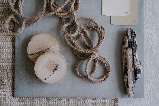 Flat lay of rustic wood pieces, rope, and driftwood on textured surfaces for design inspiration.