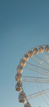 A giant ferris wheel set against a clean, clear blue sky, offering a sense of adventure and fun.