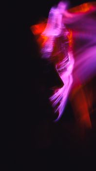 Creative abstract portrait featuring neon light trails illuminating a human face.
