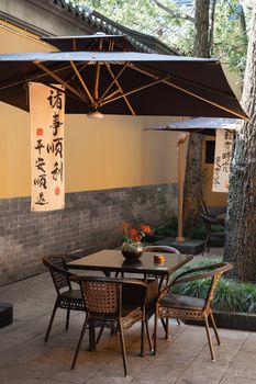 A serene outdoor tea house setting in Nanjing, China with traditional décor and lush greenery.