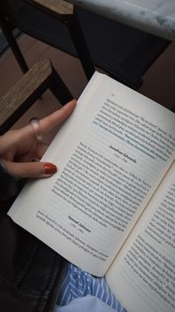 Close-up of an open book being read outdoors, creating a cozy atmosphere.