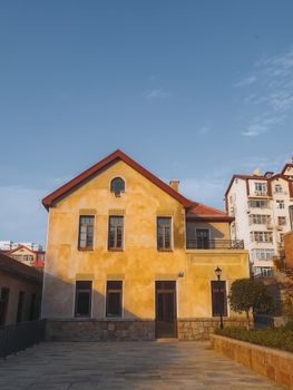 Vintage building exterior with red roof under a clear blue sky, showcasing historical architecture.