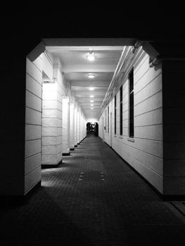 Stunning black and white photo of a timeless corridor in Hong Kong, capturing architectural symmetry and contrast.