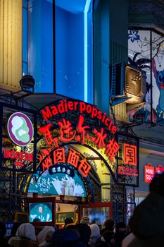Night scene of the famous Madier Popsicle shop in Harbin, China, with bright neon signs.