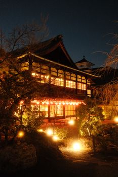 A beautifully lit traditional Japanese building at night, showcasing warm and serene architecture.