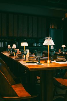 Elegant bistro table setting indoors with decorative lamps, creating a warm, inviting atmosphere.