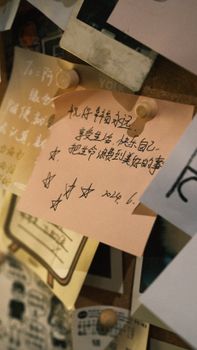 Zoomed-in view of a bulletin board filled with diverse handwritten notes and pins.