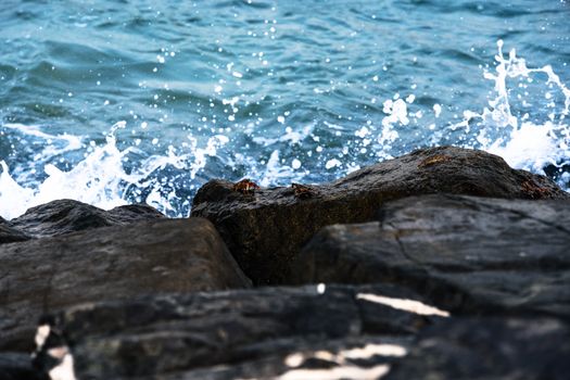 Dynamic shot of ocean waves crashing against rocks in Khor Fakkan, UAE.